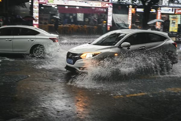 Car driving through flooded street during first rainstorm in Los Angeles